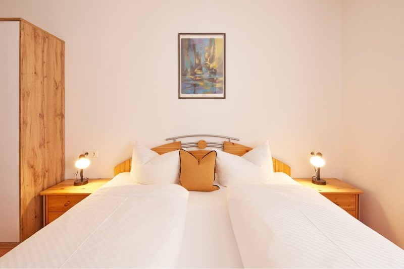 Schlafzimmer mit Doppelbett und Leselampen in der Ferienwohnung Hohe Salve