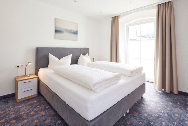 Appartement Zwoa – Schlafbereich mit Doppelbett am Fenster